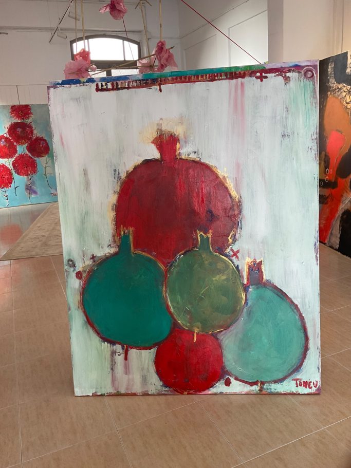 Bodegon de granadas en colores rojo y verde sobre un fondo claro. 