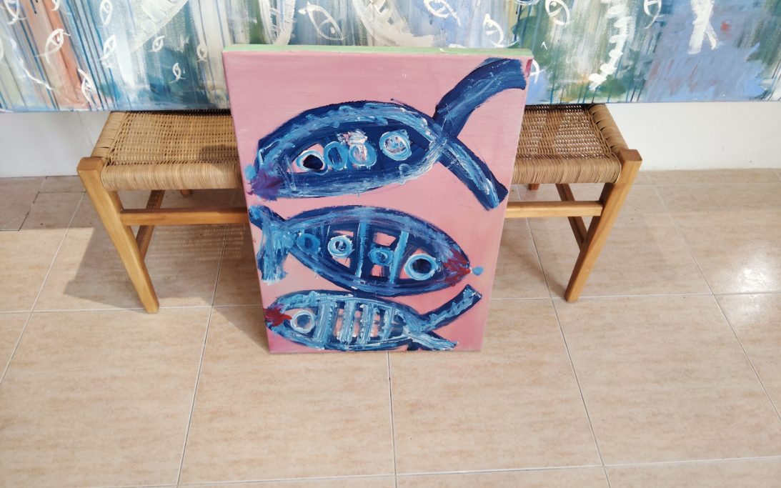 Cuadro de peces en tonos azules sobre fondo rosa,