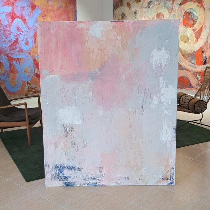 Lienzo abstracto con tonos suaves de rosa y azul en un ambiente artístico.
