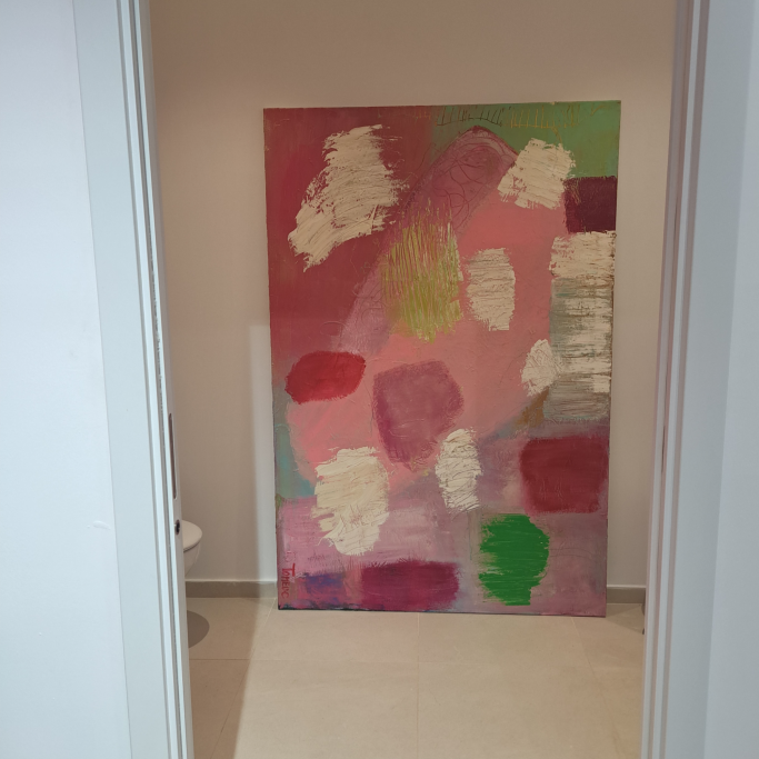 Cuadro abstracto con tonos rosas, verdes y blancos en un espacio iluminado.