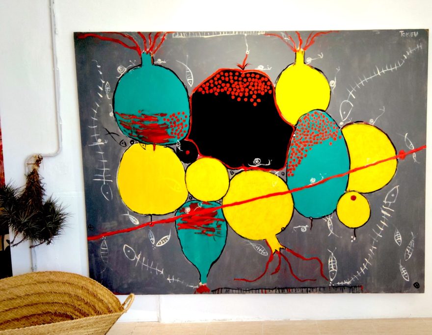 Pintura abstracta con formas redondas en amarillo, azul y negro sobre fondo gris.