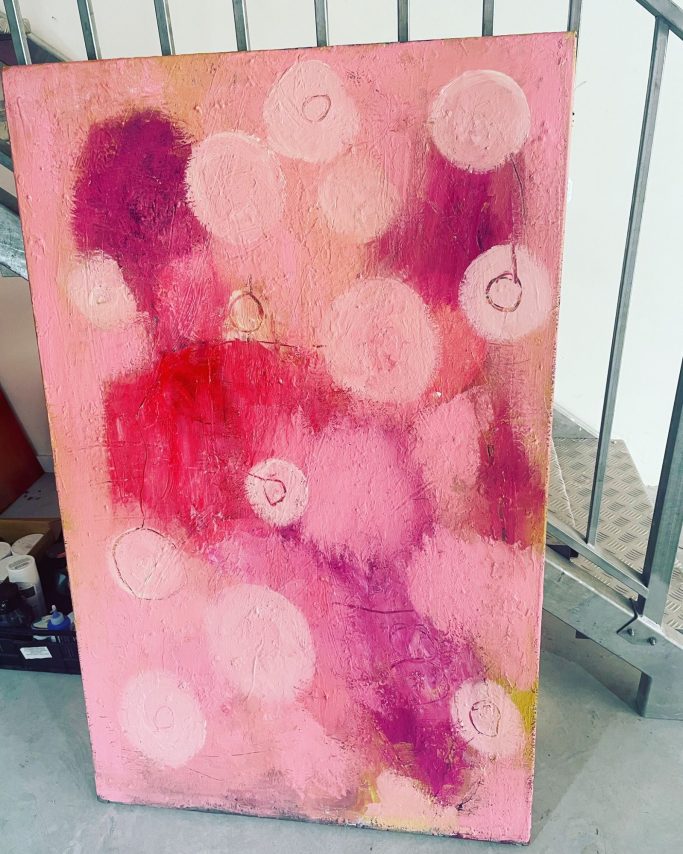 Pintura abstracta en tonos rosas con burbujas blancas y matices de color.