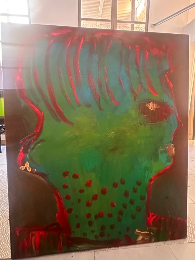 Retrato abstracto con tonos verdes y rojos, con un perfil humano distintivo.